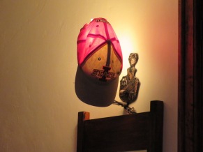Ryan's hat drying out on the wall lamp after he was caught out in the rain during his big night out on the town.